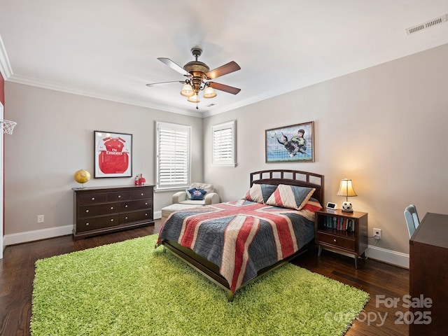 bedroom with wood finished floors, crown molding, baseboards, and visible vents