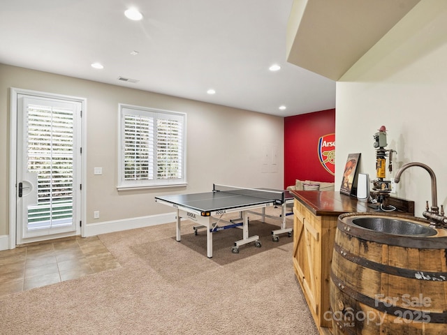 rec room with light tile patterned floors, baseboards, recessed lighting, a sink, and light carpet