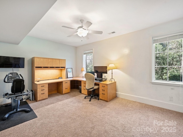 office space with light colored carpet, baseboards, visible vents, and ceiling fan