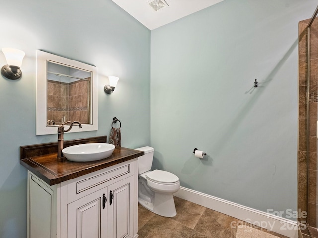 full bathroom featuring visible vents, baseboards, toilet, tiled shower, and vanity