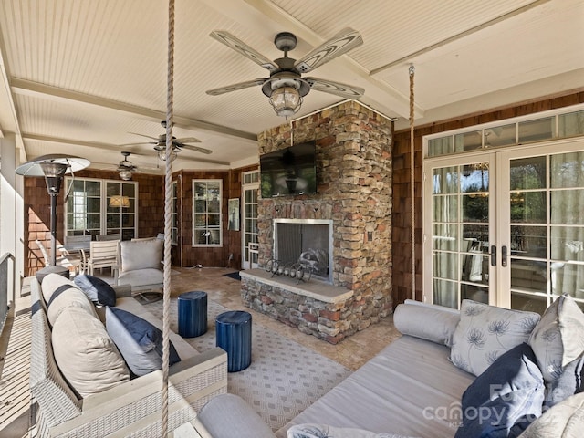 view of patio with french doors, a ceiling fan, and an outdoor living space with a fireplace