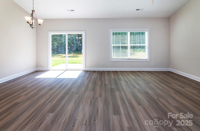 unfurnished room featuring visible vents, a healthy amount of sunlight, and dark wood-style flooring