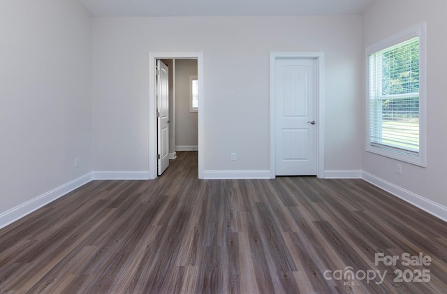 unfurnished bedroom featuring dark wood-type flooring and baseboards