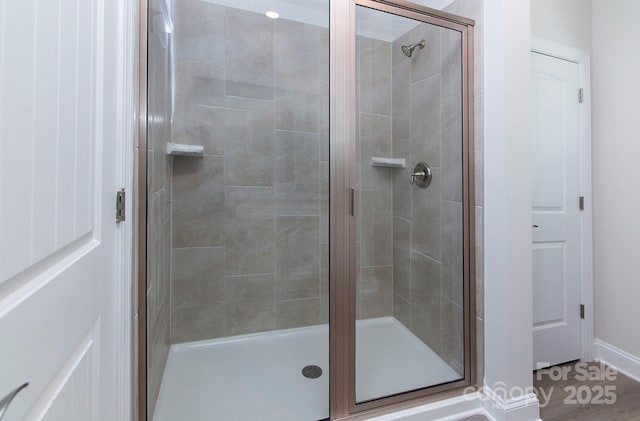 full bath with baseboards and a stall shower