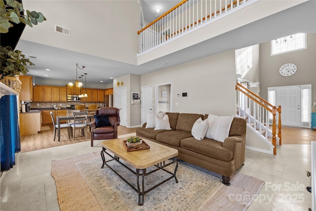 living room with baseboards, visible vents, a high ceiling, recessed lighting, and stairs