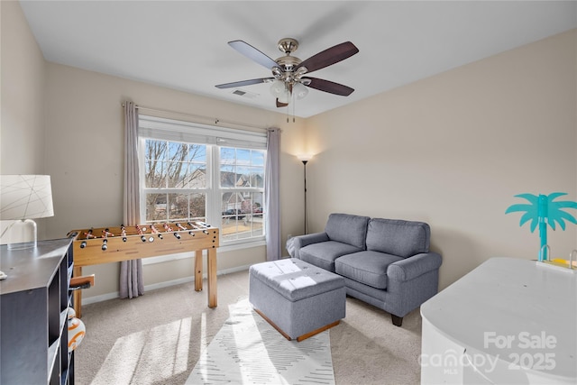 living room with light carpet, visible vents, baseboards, and a ceiling fan