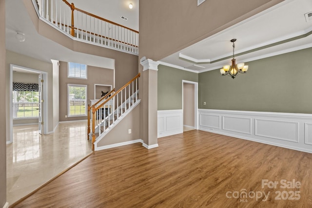 252 Legend Dr, Rock Hill, SC 29732 - unfurnished room with a chandelier, stairs, wood finished floors, a tray ceiling, and ornamental molding
