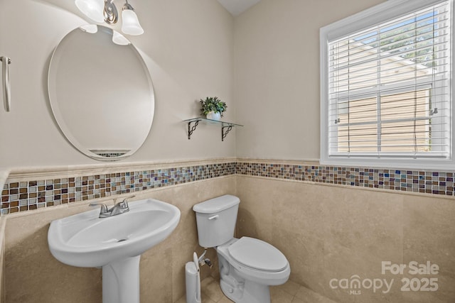 252 Legend Dr, Rock Hill, SC 29732 - half bath featuring tile walls, toilet, a wainscoted wall, plenty of natural light, and tile patterned flooring