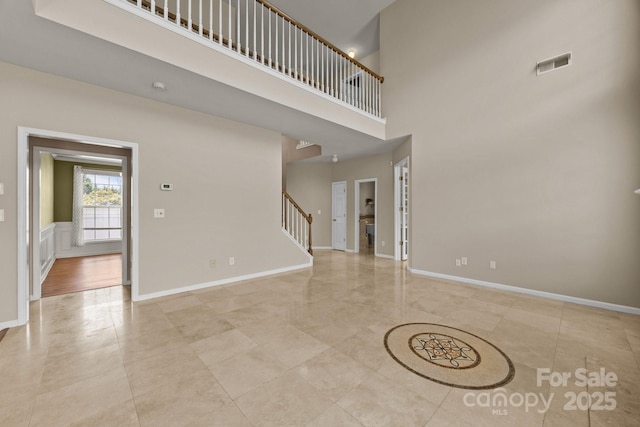 252 Legend Dr, Rock Hill, SC 29732 - unfurnished living room featuring stairway, a towering ceiling, baseboards, and light tile patterned floors