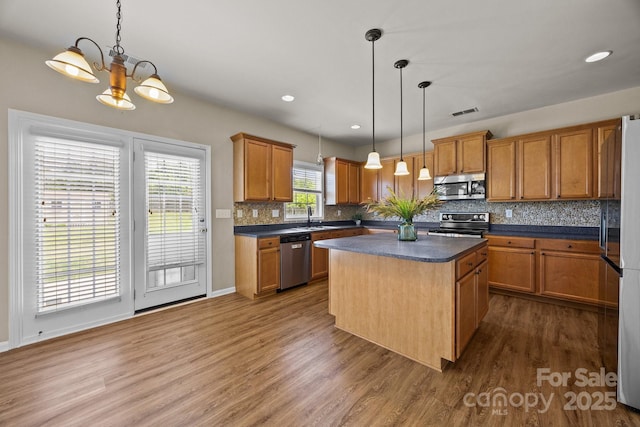 252 Legend Dr, Rock Hill, SC 29732 - kitchen with stainless steel appliances, a sink, wood finished floors, brown cabinetry, and recessed lighting
