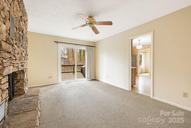 unfurnished living room featuring carpet flooring, a fireplace, baseboards, and a textured ceiling