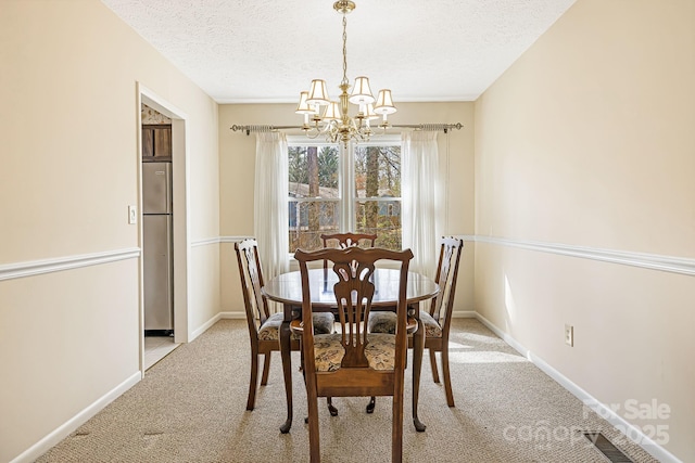 dining space featuring visible vents, baseboards, light carpet, a notable chandelier, and a textured ceiling