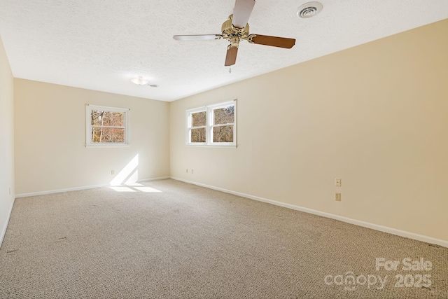 spare room featuring visible vents, baseboards, a textured ceiling, and carpet flooring