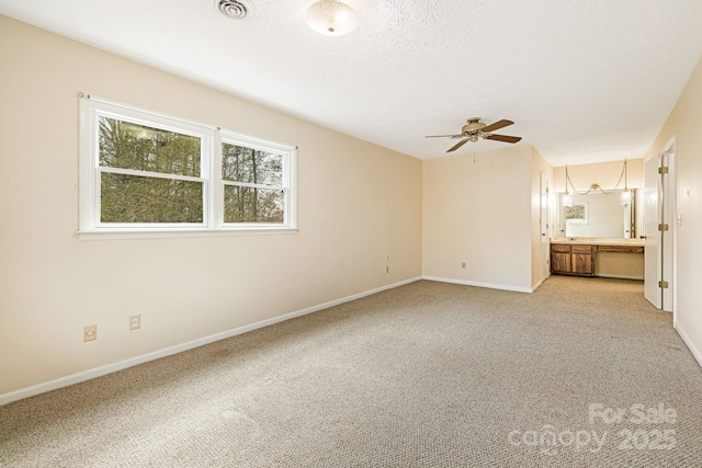 unfurnished bedroom featuring visible vents, baseboards, carpet floors, ensuite bathroom, and a textured ceiling