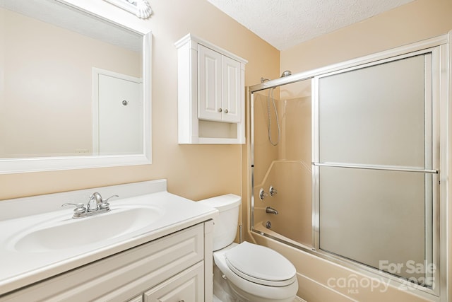 full bathroom with toilet, a textured ceiling, vanity, and bath / shower combo with glass door