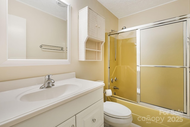 full bathroom featuring vanity, toilet, shower / bath combination with glass door, and a textured ceiling