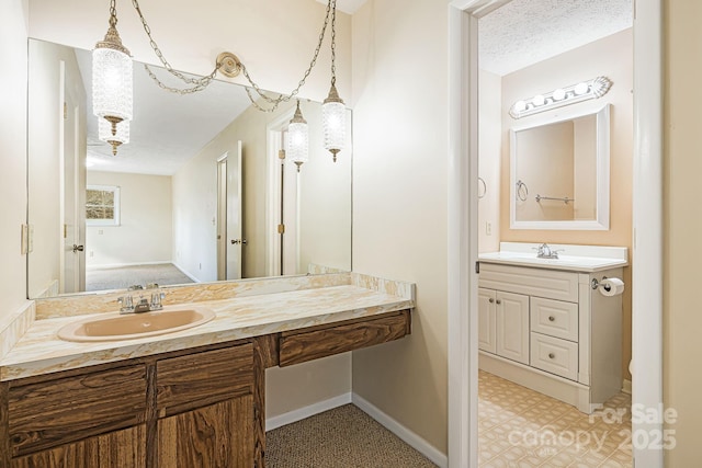 full bath with vanity, tile patterned floors, baseboards, and a textured ceiling