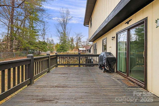 wooden terrace with area for grilling and fence