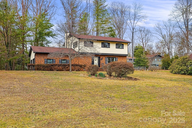 view of front of house with a front lawn and brick siding