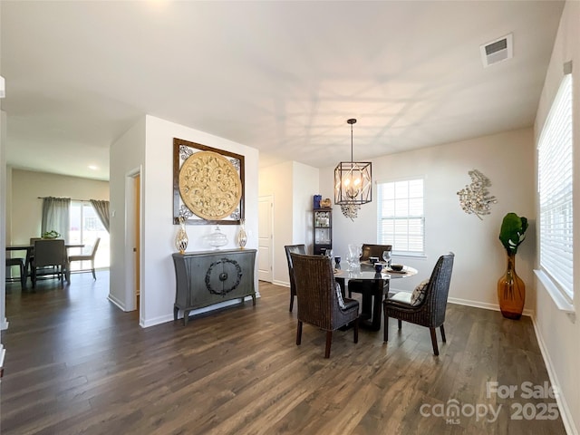 dining room featuring a notable chandelier, visible vents, baseboards, and dark wood-style flooring