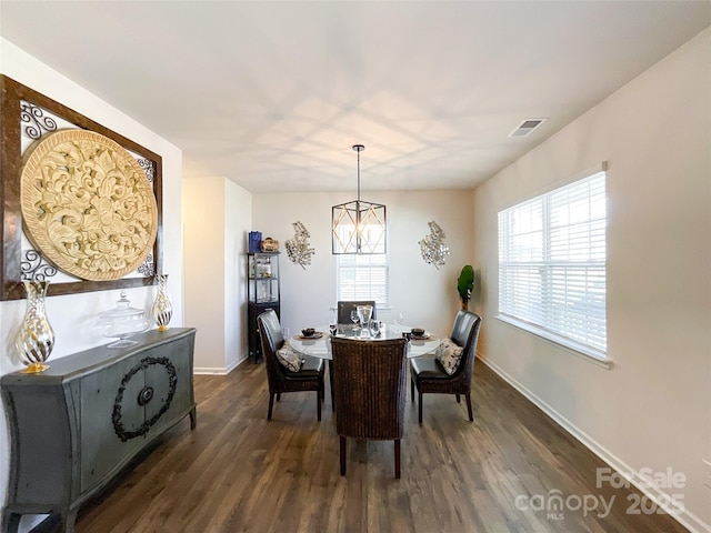 dining area featuring visible vents, a healthy amount of sunlight, and dark wood-style flooring