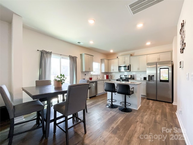 dining space with recessed lighting, wood finished floors, visible vents, and baseboards