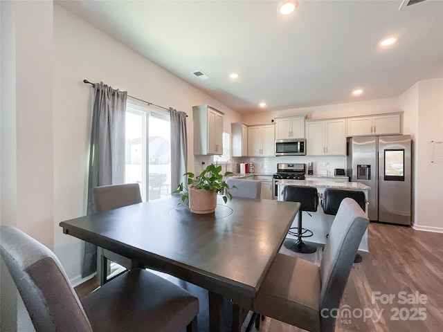 dining room with dark wood finished floors, recessed lighting, visible vents, and baseboards