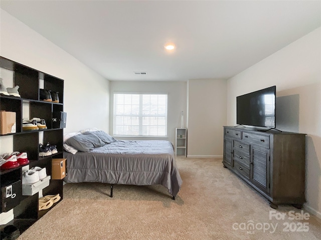 bedroom with light carpet, visible vents, and baseboards