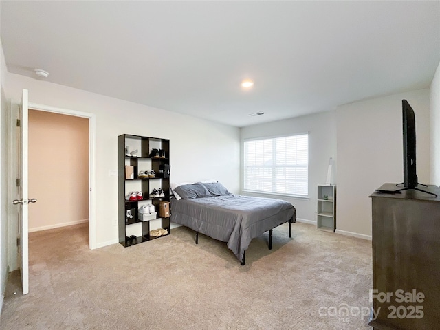 bedroom featuring visible vents, light colored carpet, and baseboards