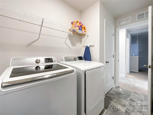 washroom featuring carpet, laundry area, separate washer and dryer, and visible vents