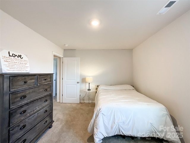 bedroom with baseboards, visible vents, and light carpet