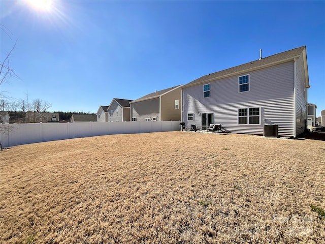 rear view of house with cooling unit and fence