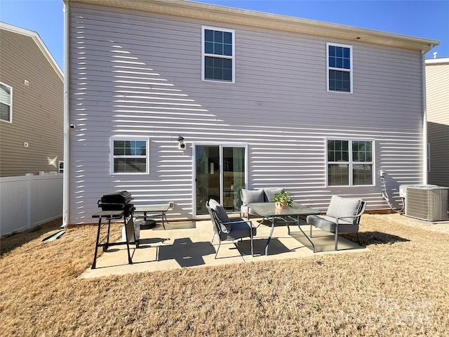 rear view of property featuring a patio area, central AC unit, and fence