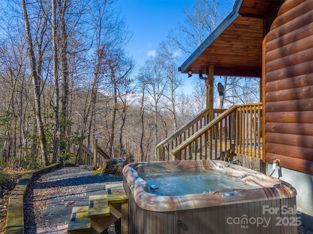 wooden terrace featuring stairs and a hot tub