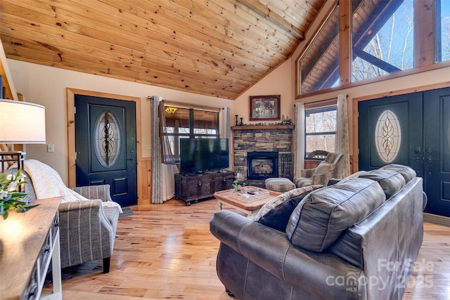 living room featuring light wood finished floors, a stone fireplace, wooden ceiling, and high vaulted ceiling