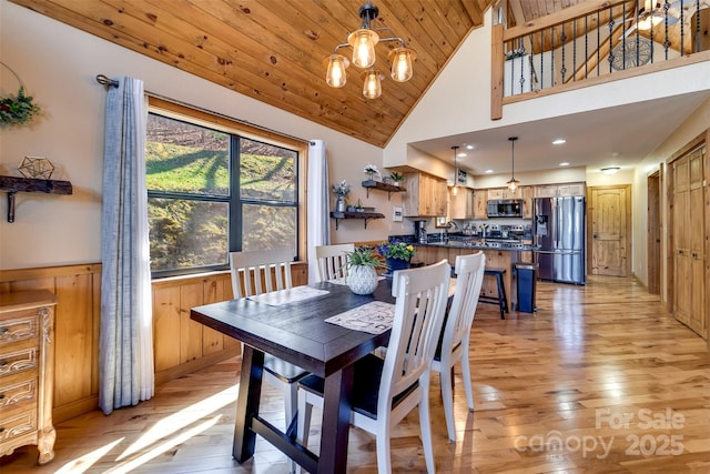 dining room with high vaulted ceiling, wood ceiling, a chandelier, and light wood finished floors