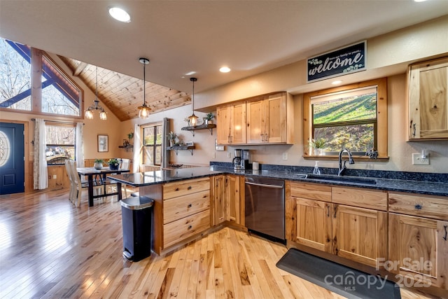 kitchen with a sink, light wood-style flooring, a peninsula, and stainless steel dishwasher