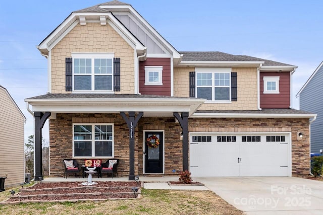 craftsman-style house featuring a shingled roof, covered porch, a garage, stone siding, and driveway