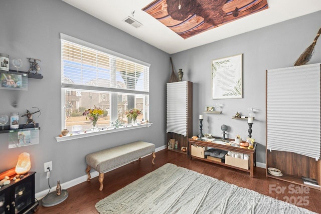 bedroom with visible vents, baseboards, and wood finished floors