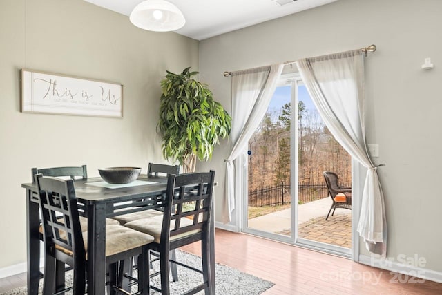 dining area featuring visible vents, wood finished floors, and baseboards