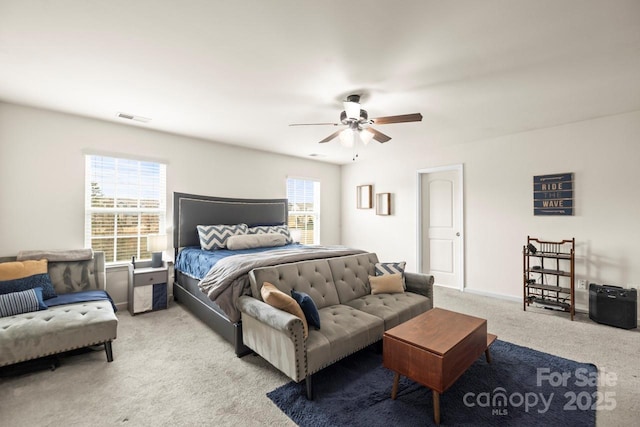 bedroom featuring visible vents, baseboards, light colored carpet, and ceiling fan