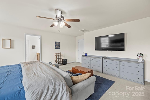 bedroom featuring visible vents, light carpet, a ceiling fan, ensuite bath, and baseboards