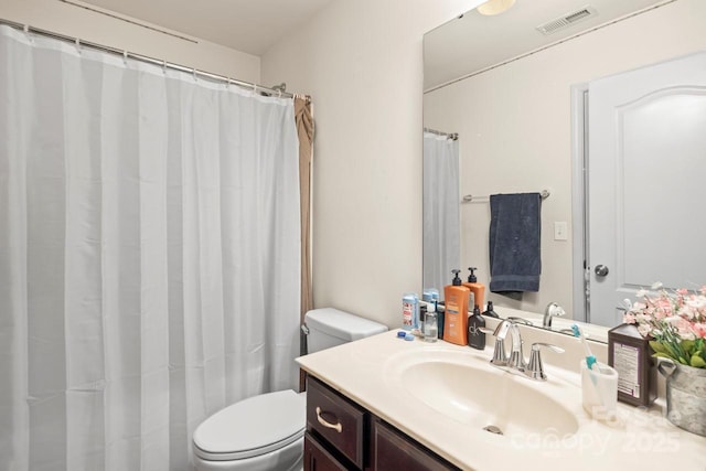 bathroom featuring visible vents, toilet, and vanity