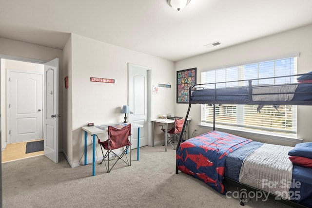 carpeted bedroom with visible vents and baseboards