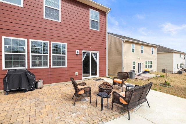 rear view of property featuring cooling unit, a patio area, fence, and an outdoor fire pit