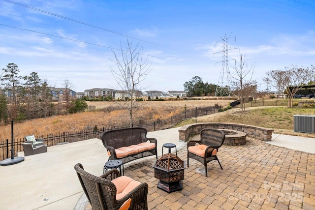 view of patio / terrace with a fire pit, central AC, and fence