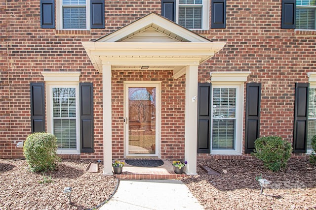 entrance to property featuring brick siding