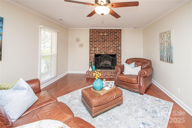 living room with a fireplace, crown molding, baseboards, and wood finished floors