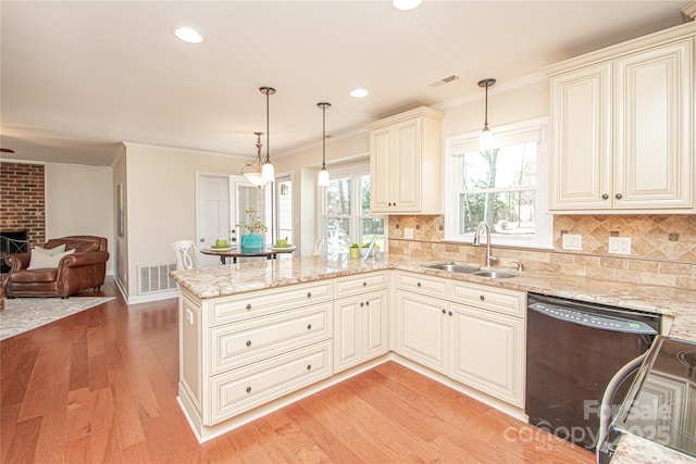 kitchen featuring dishwasher, a peninsula, visible vents, and a sink