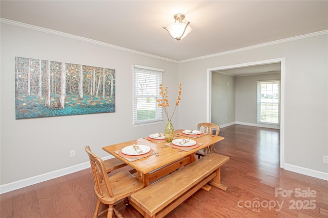 dining area featuring baseboards, wood finished floors, and crown molding